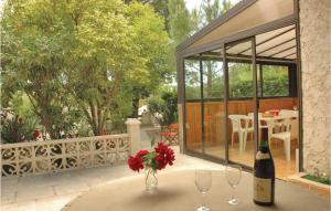 a table with a vase of flowers and a bottle of wine at Nice Home In Saint Cannat With Wifi in Saint-Cannat