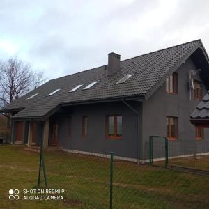 比亞沃加德的住宿－Noclegi nad Parsętą，一座带庭院的黑色屋顶房子