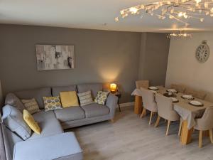 a living room with a couch and a table with chairs at Entire 3 bed home Sleeps 6, WiFi, 2 Parking Spaces in Milton Keynes