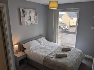 1 dormitorio con 1 cama con 2 toallas en Entire 3 bed home Sleeps 6, WiFi, 2 Parking Spaces en Milton Keynes
