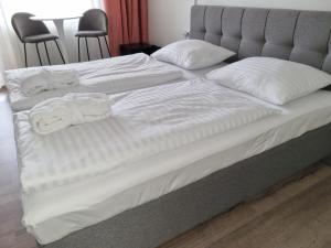 un letto con lenzuola bianche e asciugamani di Ubytování Hanka v hotelovém pokoji C408 a Frymburk