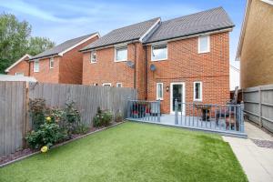 a backyard of a home with a fence at Entire 3 bed home Sleeps 6, WiFi, 2 Parking Spaces in Milton Keynes