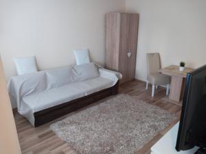 ein Wohnzimmer mit einem weißen Sofa und einem Tisch in der Unterkunft Apartman Nera in Zenica