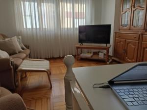 sala de estar con mesa y ordenador portátil. en Cedeira Apartamento - Floreal, en Cedeira