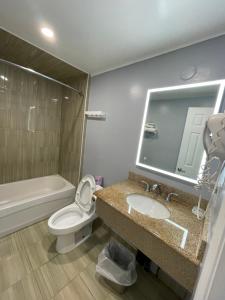 a bathroom with a sink and a toilet and a tub at Royal Inn in Burlington