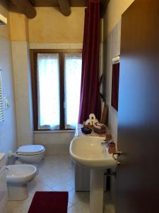 a bathroom with a sink and a toilet and a window at Casa Giulia - Tramonto - Valeggio sul Mincio in Valeggio sul Mincio