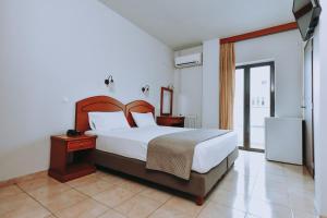 a hotel room with a bed and a dresser at Athinaiko Hotel in Heraklio