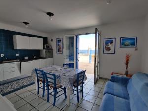 a kitchen and dining room with a table and chairs at Villino sul mare in San Foca