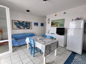 a living room with a table and a blue couch at Villino sul mare in San Foca