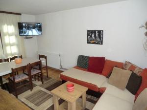 een woonkamer met een bank en een tafel bij Holiday Home Minja in Kopaonik