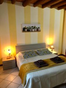 a bedroom with a bed with two lamps and a shelf with plants at Casa Giulia - Tramonto - Valeggio sul Mincio in Valeggio sul Mincio