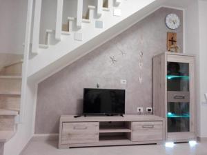sala de estar con TV en un vestidor bajo una escalera en Cala Sardinia Apartment, en Viddalba