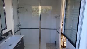a white bathroom with a shower and a sink at La Criste Marine in Groix +20 photos