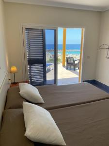 een slaapkamer met 2 bedden en uitzicht op de oceaan bij RentOnTheBeach in Los Cristianos