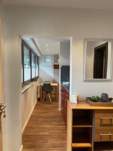 a hallway leading into a kitchen with a table and a desk at City-Apparte ONE - Auto-E-Ladestation in Gronau