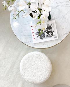 a round white table with a white rug and white flowers at Lolita Lux - Belgrade Waterfront in Belgrade