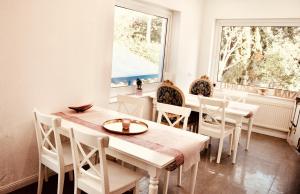 a dining room with a table and chairs and a window at Villa am Südpark in Bad Nauheim