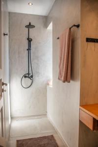 a bathroom with a shower with a towel on the wall at La belle Hélène in Spetses