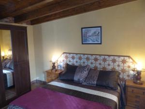 ein Schlafzimmer mit einem Bett mit zwei Nachttischen und zwei Lampen in der Unterkunft Casa de la Abuela Pili in Colmenar de Oreja
