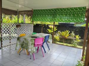 d'une terrasse avec une table et des chaises colorées. dans l'établissement Le spot, à Fare