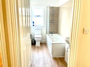 a bathroom with a toilet and a sink and a window at Holiday Flat in Central Slough near to London Heathrow and Windsor with Free Car Park in Slough