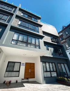 a large apartment building with a brown door at DE LUXE BOUTIQUE & rooftop in Chiang Mai