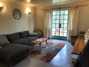 sala de estar con sofá y mesa en Tegwaan Country Getaway, en Waterval Boven