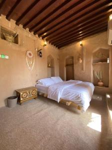 ein Schlafzimmer mit einem großen Bett und einem Tisch in der Unterkunft نزل حارة المسفاة Harit AL Misfah Inn in Misfāh