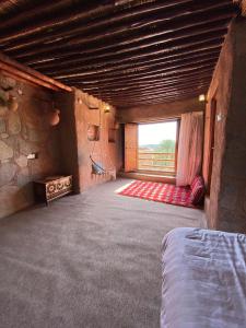 Großes Zimmer mit einem Bett und einem Fenster in der Unterkunft نزل حارة المسفاة Harit AL Misfah Inn in Misfāh