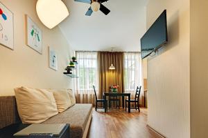 a living room with a couch and a table at RigaApartment SoNaDA Self Check-in Aparthotel, Center, Private Parking in Riga
