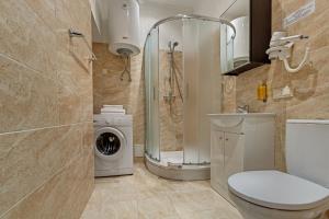 a bathroom with a toilet and a washing machine at RigaApartment SoNaDA Self Check-in Aparthotel, Center, Private Parking in Riga