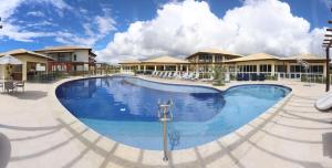 a large swimming pool in front of a resort at Baixio - Praia e pé na areia! Ponta de Inhambupe in Esplanada