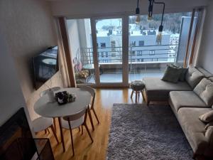 a living room with a couch and a table at Bjelašnica mountain view apartment in Bjelašnica
