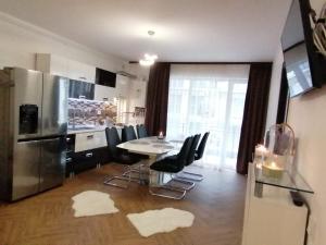 a kitchen with a table and chairs and a refrigerator at Iris Vivo Mall in Cluj-Napoca