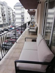 - un canapé blanc sur le balcon d'un immeuble dans l'établissement Iris Vivo Mall, à Cluj-Napoca