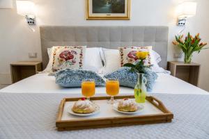 een dienblad met eten en drinken op een bed bij Bed and Breakfast Port Inn in Civitavecchia