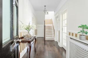 a hallway with white walls and a table with flowers on it at Family Home By The Sea in Torquay