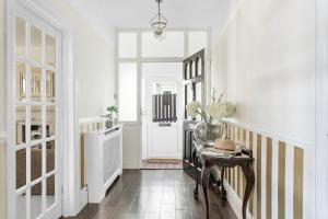 a hallway with a table and a white door at Family Home By The Sea in Torquay