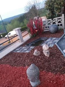 un jardín con rocas, un banco y flores en maison à la campagne prés de la ville, en Aiglemont