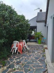 un tavolo e sedie seduti su un patio in pietra di maison à la campagne prés de la ville a Aiglemont