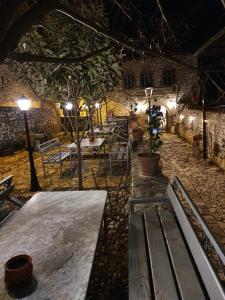 a group of tables and benches in a courtyard at night at Hotel Klea in Berat