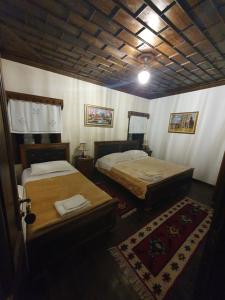a room with two beds in a room with a rug at Hotel Klea in Berat