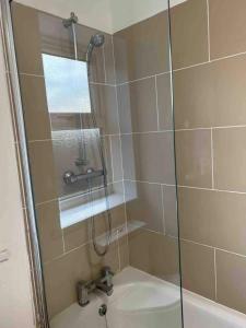 ducha con puerta de cristal y lavamanos en Holiday Flat in Central Slough near to London Heathrow and Windsor with Free Car Park en Slough