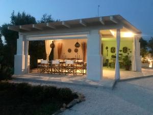 a pavilion with a table and chairs on a patio at Trulli Pietraverde in Ceglie Messapica