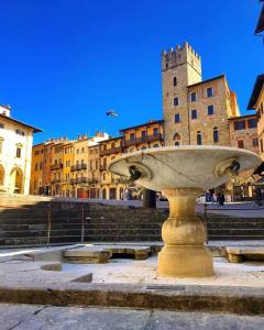 a stone fountain in front of some buildings at La Corte Del Re Suite & Rooms Arezzo in Arezzo +182 photos