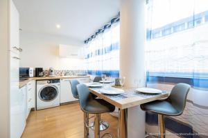 a kitchen with a table and chairs in a room at Le BLUE BAY--T2--TOUT CONFORT--HYPER CENTRE--WIFI in Tarbes