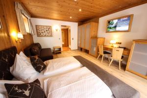 a bedroom with a bed and a desk at TALHEIMER Grias di & Hoamat since 1958 inklusive Therme TAUERN SPA & Jokercard in Saalbach-Hinterglemm