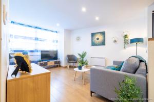 a living room with a couch and a tv at Le BLUE BAY--T2--TOUT CONFORT--HYPER CENTRE--WIFI in Tarbes
