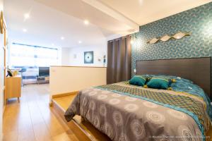 a bedroom with a large bed with blue walls at Le BLUE BAY--T2--TOUT CONFORT--HYPER CENTRE--WIFI in Tarbes