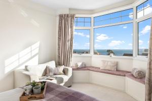 a bedroom with a window seat with a chair and a couch at Family Home By The Sea in Torquay